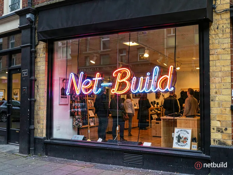 Eine Leuchtreklame aus Neon in einem Schaufenster auf der steht: "Net-Build"